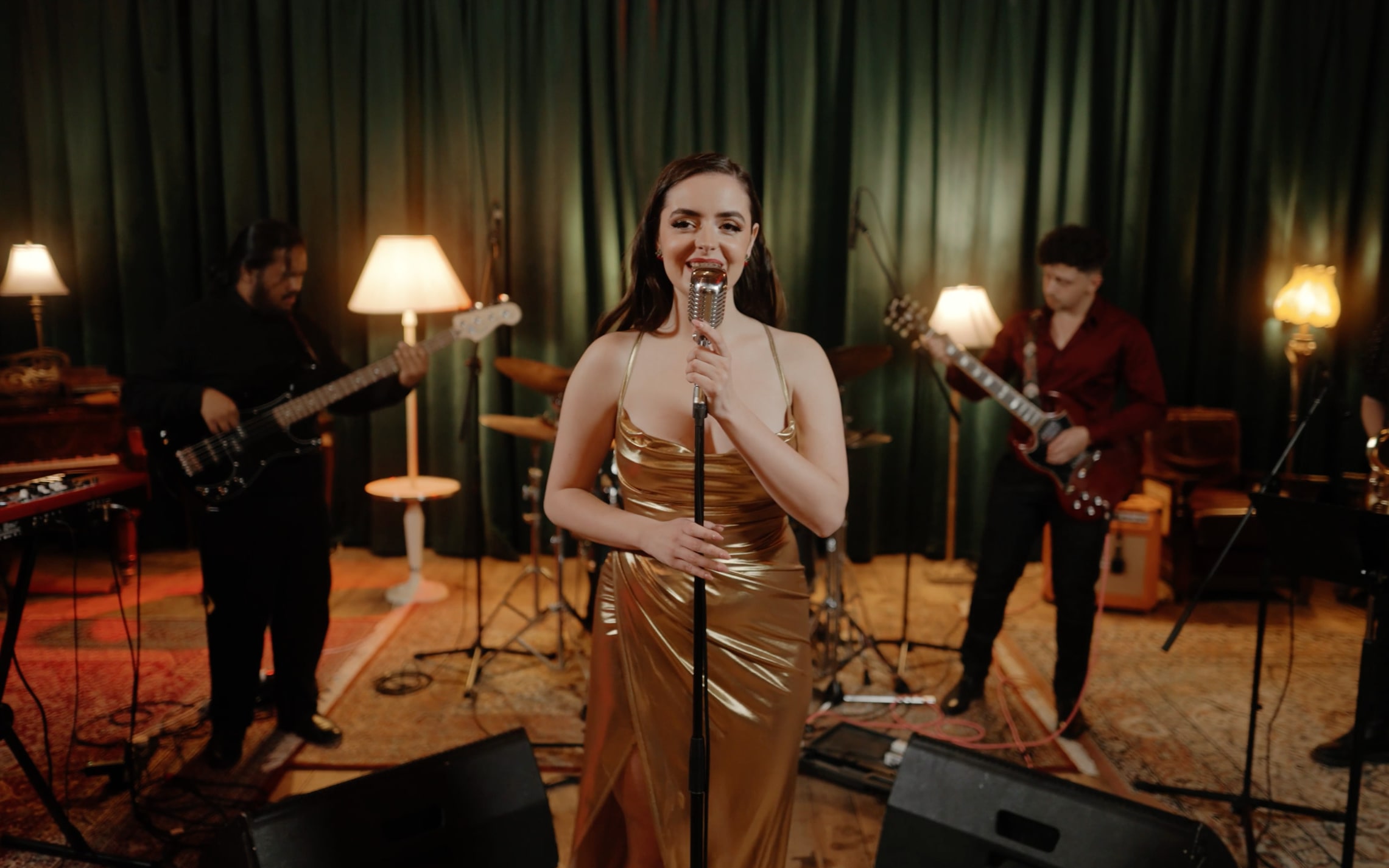 Abbey in a gold satin gown singing with Cherry Lane, guitarists and saxophonist either side of her