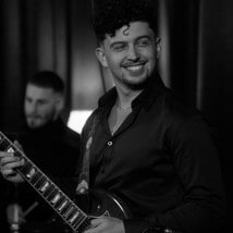 Hunter smiling and playing electric guitar