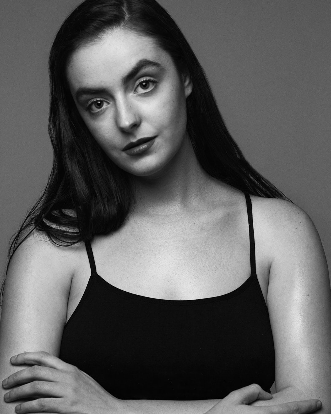 Black and white headshot of Abbey in a black singlet with her arms crossed